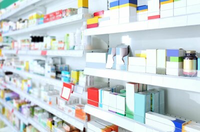 Regale im Drogeriemarkt Weiße Regale in einem Drogeriemarkt mit verschiedenen Medikamentenpackungen und Gesundheitsprodukten.