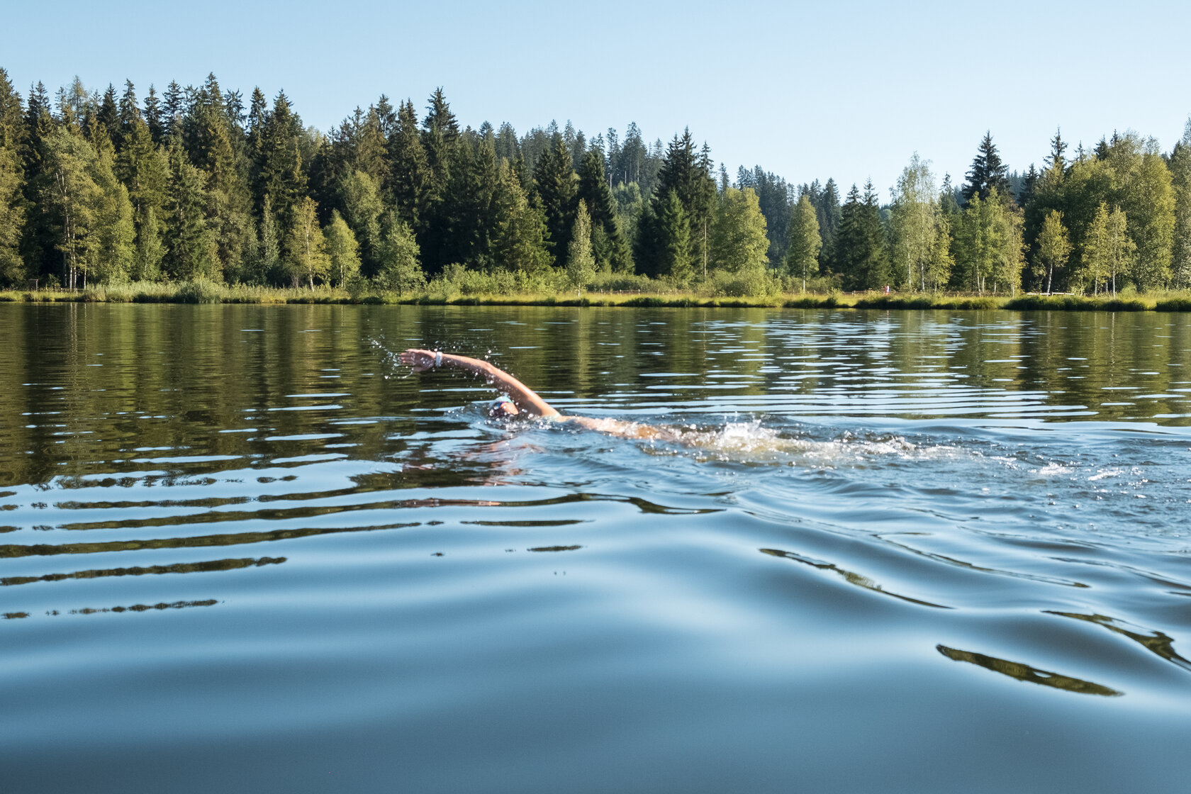 Eine Frau schwimmt im Schwarzsee in Kitzbühel