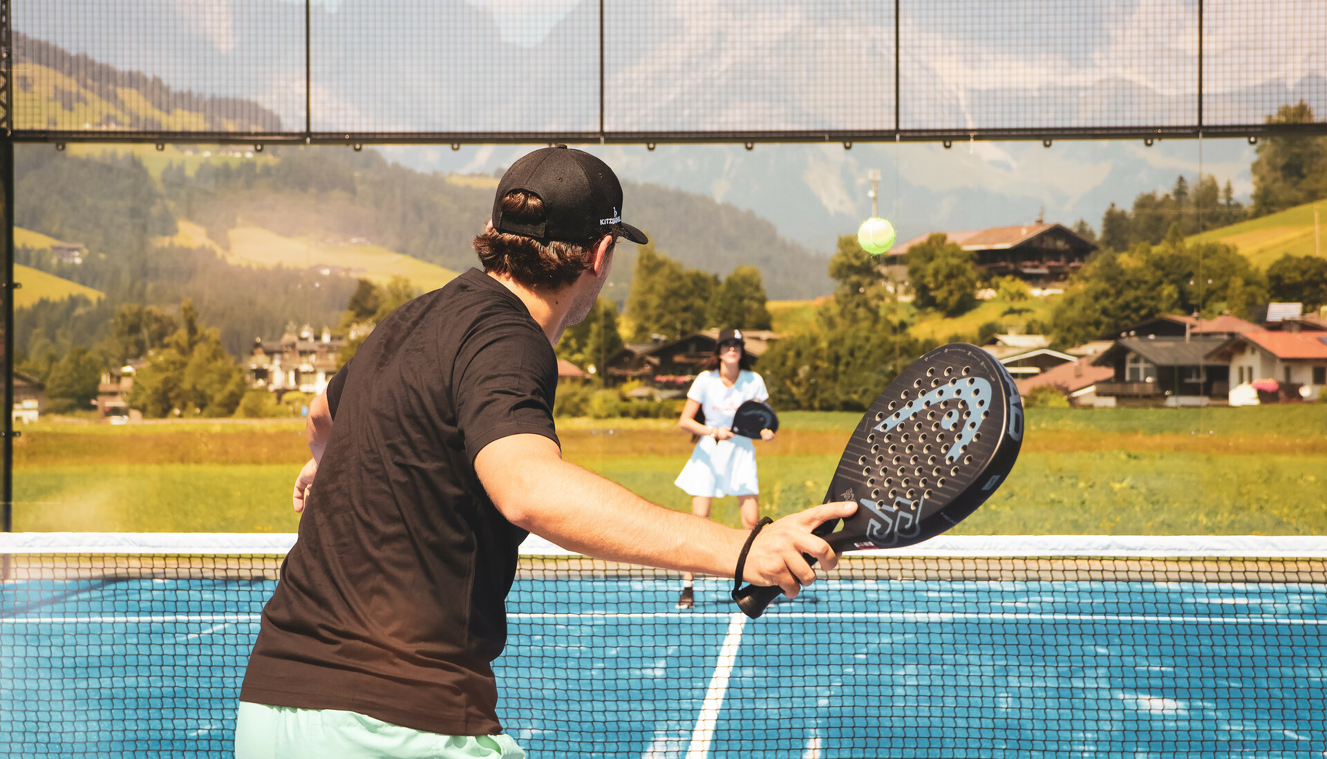 Zwei Menschen spielen Padel Tennis vor beeindruckender Kulisse