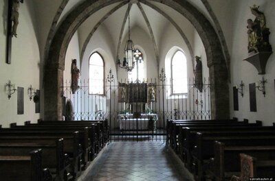 Katharinenkirche Eine ruhige Kirche mit hohen Gewölben und Holzbank. Der Altarbereich ist von einem Gitter umgeben, und das Licht fällt durch die Fenster hinein.