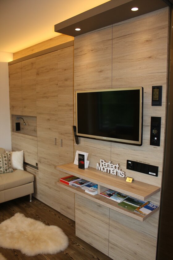 Wohnbereich Designappartment Jochberg Moderner Wohnbereich mit TV an einer Holzwand und Sofa.