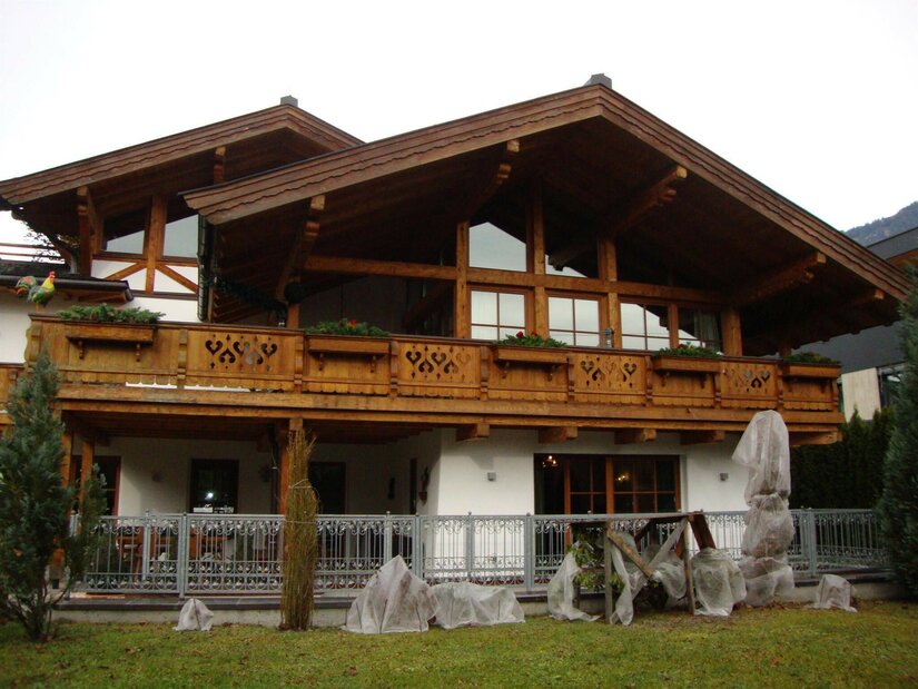 Haus Andreas in Kitzbühel Alpines Wohnhaus aus Holz und weißem Putz mit großem Balkon und Garten.