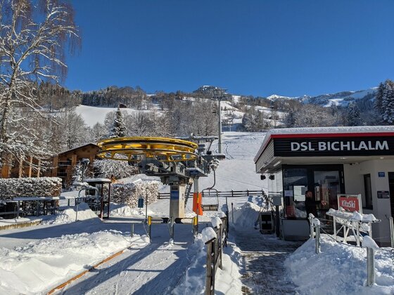 Talstation Sessellift Bichlalm Talstation des Sessellifts Bichlalm in einer verschneiten Winterlandschaft unter blauem Himmel.