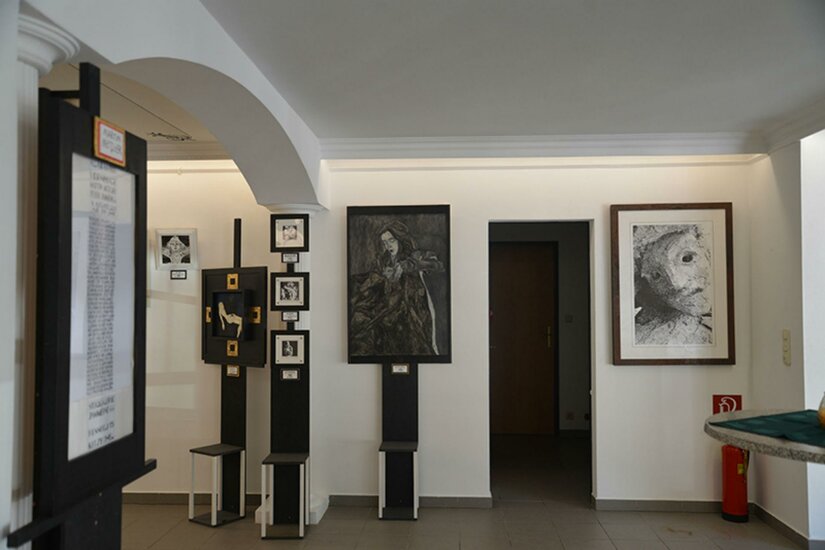 Ausstellungsraum der Stuck Galerie Innenansicht einer Kunstgalerie mit verschiedenen gerahmten Porträts und Grafiken an weißen Wänden.