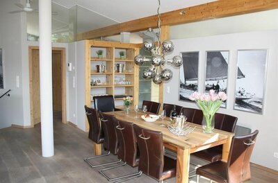 Moderner Essbereich mit Holztisch, Lederstühlen und einer auffälligen Kugelleuchte.