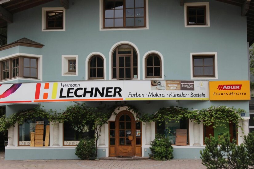 Lechner Maler und Künstlerbedarf Fassade des Geschäfts Hermann Lechner für Farben und Künstlerbedarf mit hellblauer Wand und Holztür.