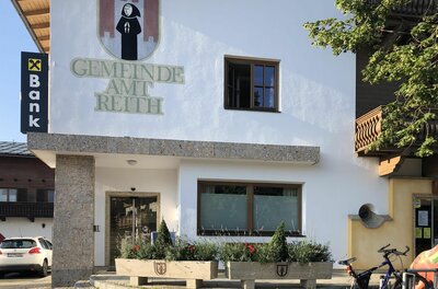 Gemeindeamt Reith Außenansicht des Gemeindeamts Reith mit Wappen und Schriftzug an der weißen Fassade.