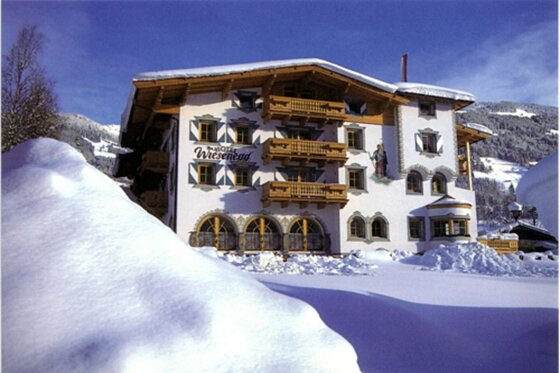 Hotel Wiesenegg im Winter Vorderansicht des Hotel Wiesenegg im Winter mit schneebedecktem Dach und hohen Schneewechten im Vordergrund.