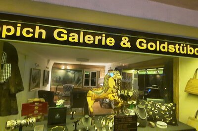 Ein Schaufenster mit der Aufschrift „Teppich Galerie & Goldstückchen“. Die Ausstellung zeigt Schmuck und Accessoires.