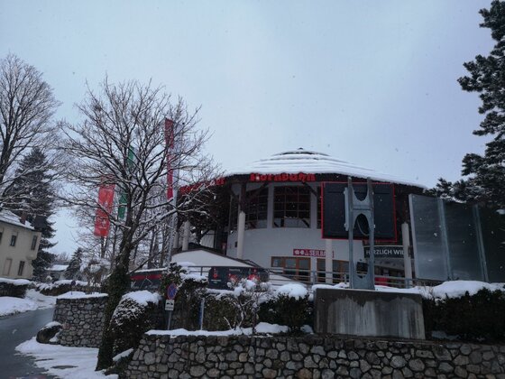 Gebäude am Ölberg Rundes Gebäude mit schneebedecktem Dach hinter einer Steinmauer im Winter.
