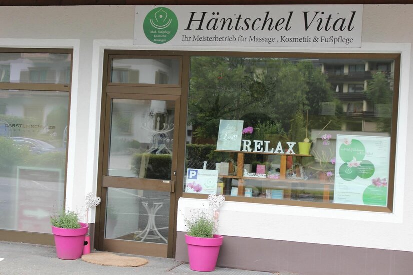 Außenansicht des Geschäfts Häntschel Vital mit Schaufenster und pinken Blumentöpfen.