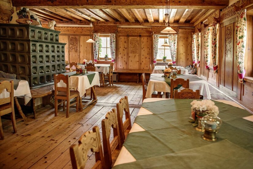 Gaststube Gasthof Alte Wacht Rustikale Gaststube mit Holztischen, Kachelofen und holzgetäfelten Wänden.