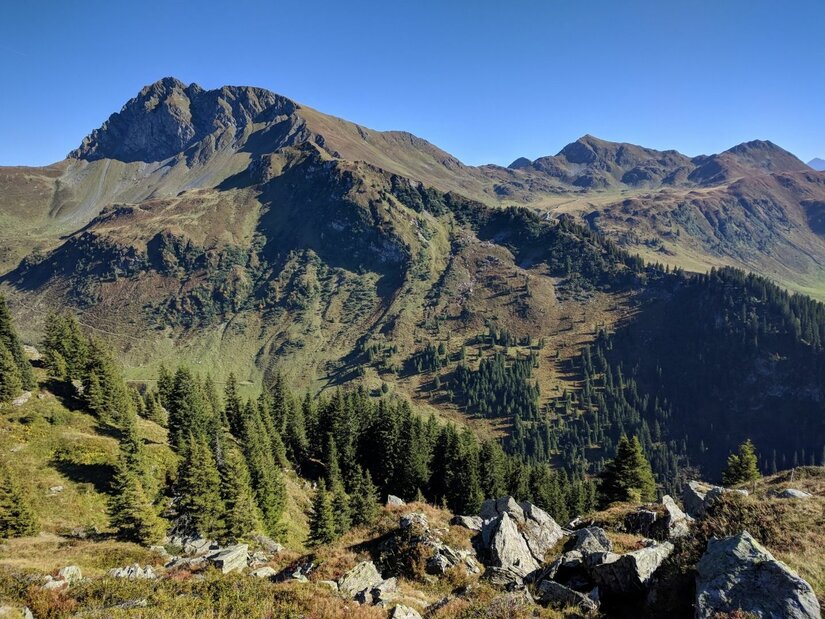 Gipfelpanorama des Geißsteins Blick auf den felsigen Gipfel des Geißsteins mit bewaldeten Hängen unter blauem Himmel.