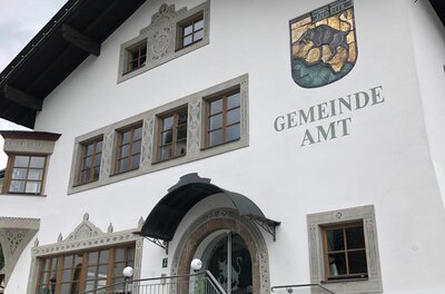 Gemeindeamt Jochberg Weiße Fassade des Gemeindeamts Jochberg mit Wappen und Schriftzug.