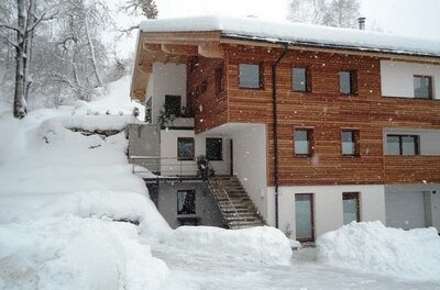 Winter am Genner Modernes Holzhaus mit Schneebedeckung im Winter.
