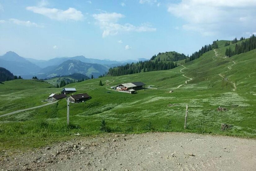 Lämmerbichlalm in den Bergen Blick auf die Lämmerbichlalm mit mehreren Almgebäuden auf grünen Bergwiesen und Wanderwegen.