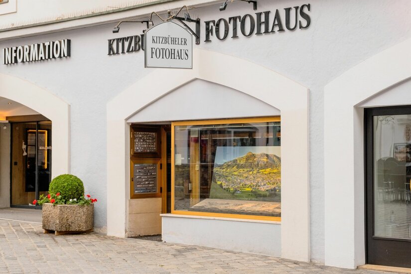 Fotohaus Lazzari in Kitzbühel Außenansicht des Kitzbüheler Fotohauses mit Schaufenster und Firmenschild an einer hellen Fassade.