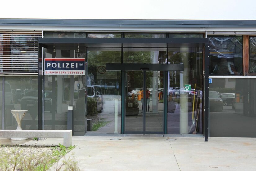 Eingangsbereich einer Polizeistation mit Glasschiebetür und Schild Bürgerservicestelle.