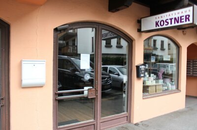 Ein Geschäft mit einer Eingangstür und Fenstern. Über der Tür steht der Schriftzug "KOSTNER".