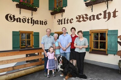 Gastgeber Gasthof Alte Wacht Fünf Erwachsene, ein Kind und ein Berner Sennenhund vor dem Gasthaus Alte Wacht.