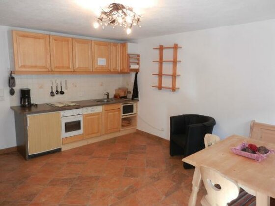 Küche der Ferienwohnung Küche mit Holzfronten, Fliesenboden und angrenzendem Esstisch.
