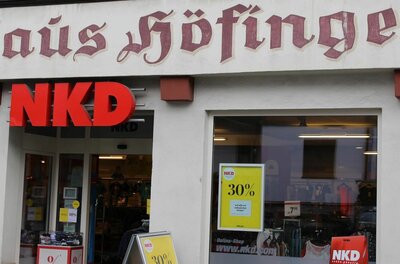 Fassade eines NKD-Modegeschäfts im Haus Höfinger mit Schaufenstern und Werbeplakaten.