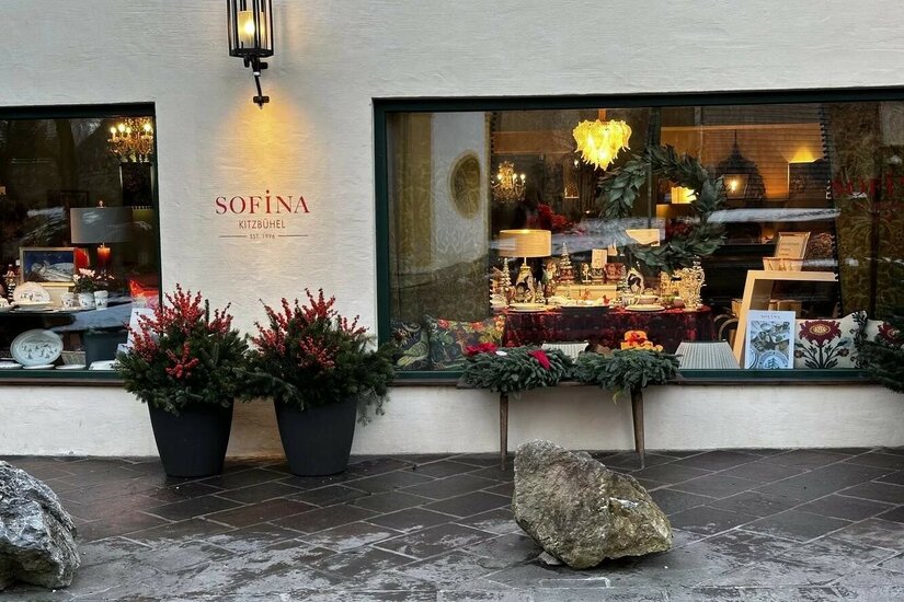 Sofina Kitzbühel Schaufenster Schaufenster des Geschäfts Sofina in Kitzbühel mit weihnachtlicher Dekoration und beleuchteter Außenwand.