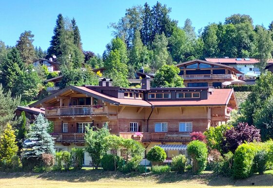 Hausansicht <p>Die Hausansicht des Golfweg Appartements, eingebettet in eine grüne Landschaft. Die Umgebung ist von Bäumen und Sträuchern umgeben, was eine ruhige Atmosphäre schafft.</p>