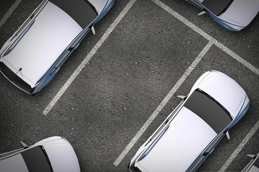 Parkplatz Hausleitenlift Draufsicht auf einen Asphaltparkplatz mit markierten Stellflächen und hellen Pkw.