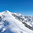 Skitourengebiet Bichlalm in Kitzbühel mit schneebedeckten Hügeln, Nadelbäumen und blauem Himmel.