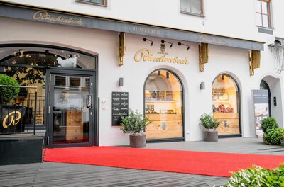 Juwelier Rüschenbeck Außenansicht des Juweliergeschäfts Rüschenbeck mit rotem Teppich vor dem Eingang.