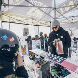 Lifestyle-Event in Kitzbühel mit Snowboard-Präsentation und aktiven Teilnehmern am Stand.