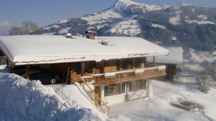 Chalet Bockberg im Winter Schneebedecktes Holzchalet mit Balkon vor einer alpinen Bergkulisse im Winter.