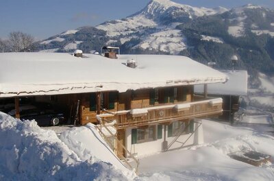 Chalet Bockberg im Winter Schneebedecktes Holzchalet mit Balkon vor einer alpinen Bergkulisse im Winter.