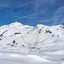 Eine schneebedeckte Berglandschaft mit Skiliften und einem klaren blauen Himmel, ideal für Wintersportler.