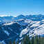 Eine atemberaubende Winterlandschaft mit schneebedeckten Bergen und einem klaren blauen Himmel über den Kitzbüheler Alpen.