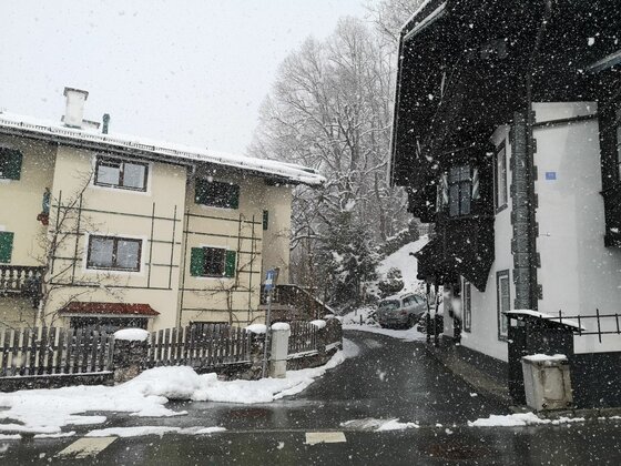 Winterliche Straße am Ölberg Verschneite Dorfstraße mit alpinen Häusern bei leichtem Schneefall.