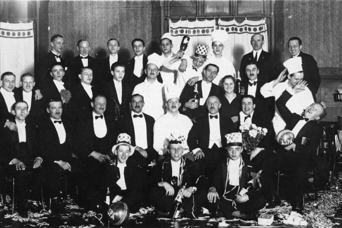 A group of men are posing in tuxedos for a photo