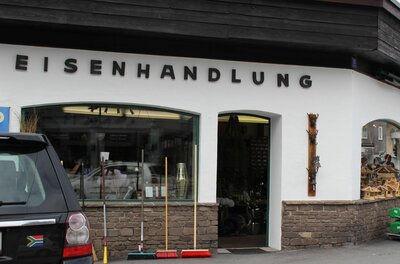 Außenansicht einer Eisenhandlung mit Schaufenster, Besen vor der Tür und dem Schriftzug Eisenhandlung.