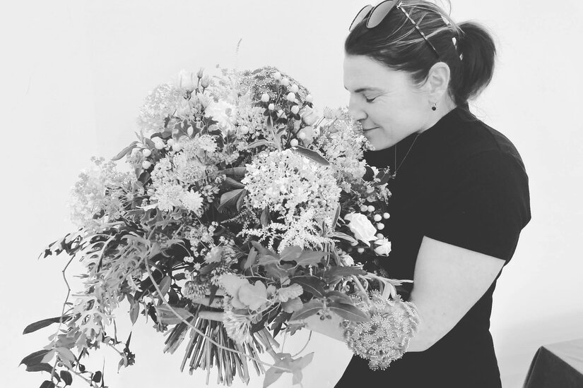Helene mit Blumenstrauß Schwarz-Weiß-Aufnahme einer Frau, die an einem großen Blumenstrauß riecht.