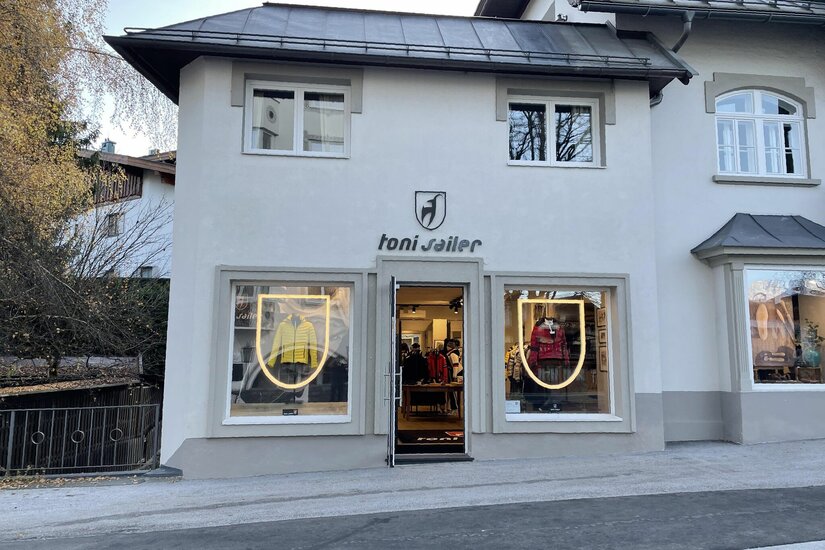 Außenansicht des Toni Sailer Sportgeschäfts mit Schaufenstern und Logo an der hellen Fassade.
