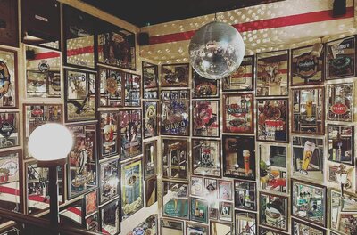Lichtl Musicbar Innenansicht Innenansicht einer Bar mit vielen gerahmten Werbeplakaten an den Wänden und einer Discokugel an der Decke.