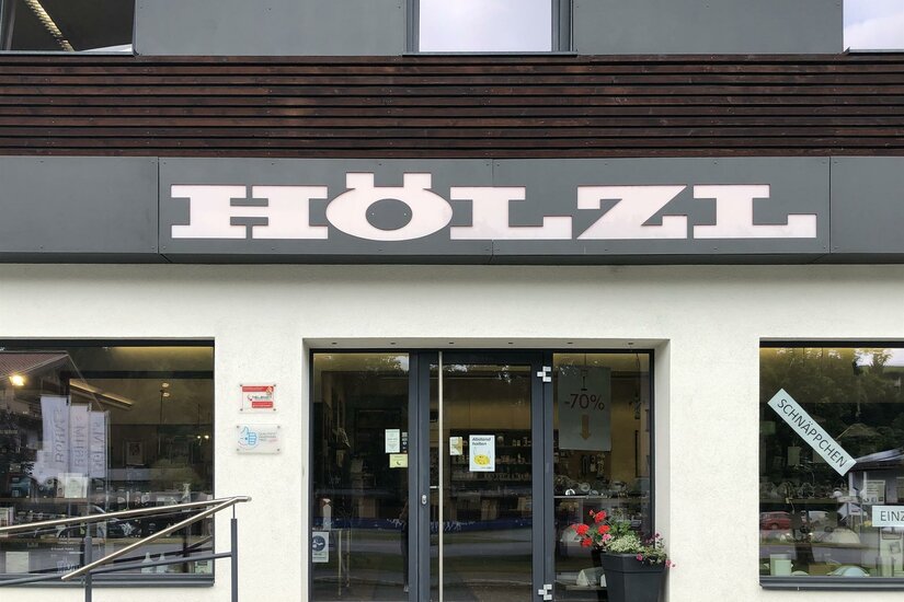 Elektro Hözl Ein Geschäft mit dem Namen "HÖLZL". Die Eingangstür ist einladend und hat große Fenster.