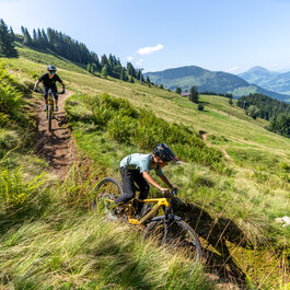 Biker fahren einen Biketrail in Kitzbühel hinunter