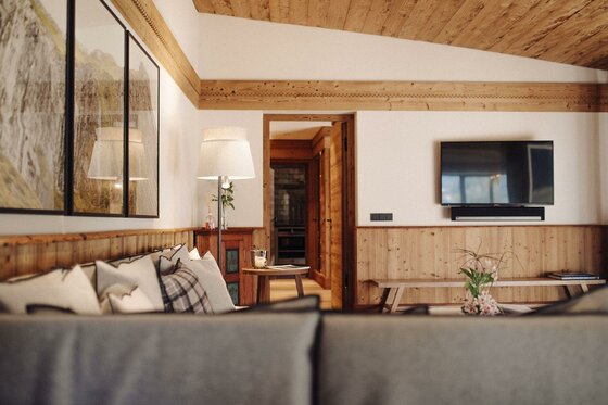 Master Lodge Wohnzimmer Modernes Wohnzimmer mit Holzdecke, Sofa, Stehlampe und Fernseher an einer hellen Wand.