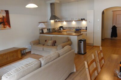 Wohnbereich Fraser Wohnungen Wohnbereich mit beigen Sofas und offener Küchenzeile in einer Ferienwohnung.