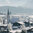 Winterlandschaft in Reith bei Kitzbühel mit Kirche und Häusern, umgeben von verschneiten Bäumen.
