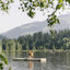 Eine Familie genießt einen sonnigen Tag auf einer schwimmenden Insel am Schwarzsee in Kitzbühel und bewundert die Natur mit dem Kitzbüheler Horn im Hintergrund.