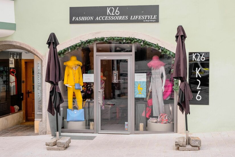 Eingangsbereich des Modegeschäfts K26 mit Schaufensterpuppen in gelber und gestreifter Kleidung.