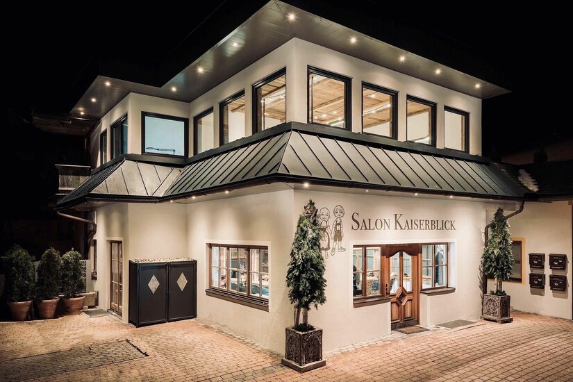 Salon Kaiserblick Außenansicht Beleuchtete Außenansicht des zweistöckigen Gebäudes Salon Kaiserblick bei Nacht.